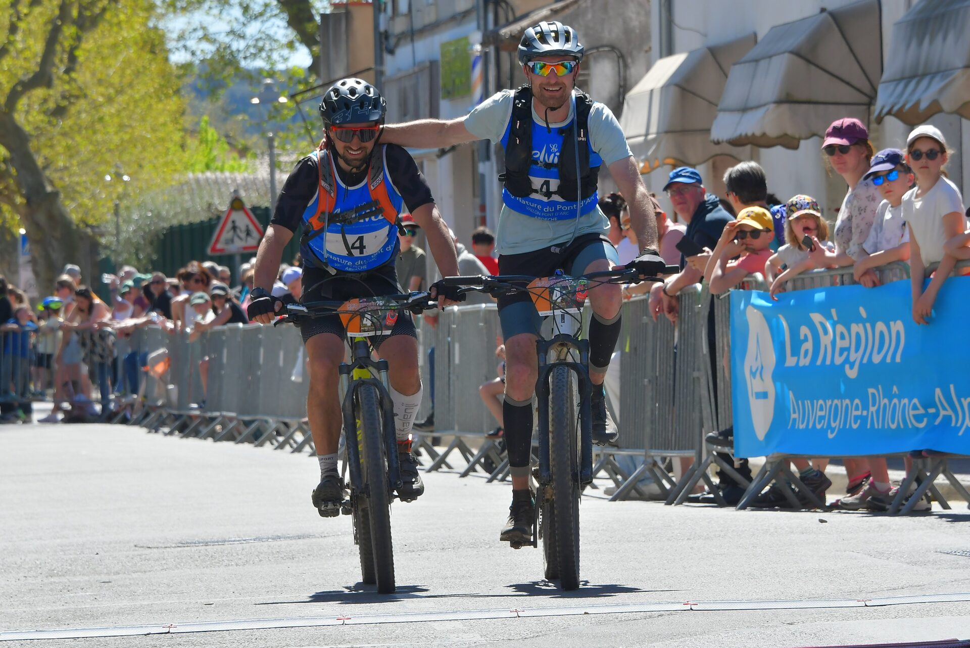 Duo de vététistes souriants à l'arrivée du raid en équipe en Ardèche