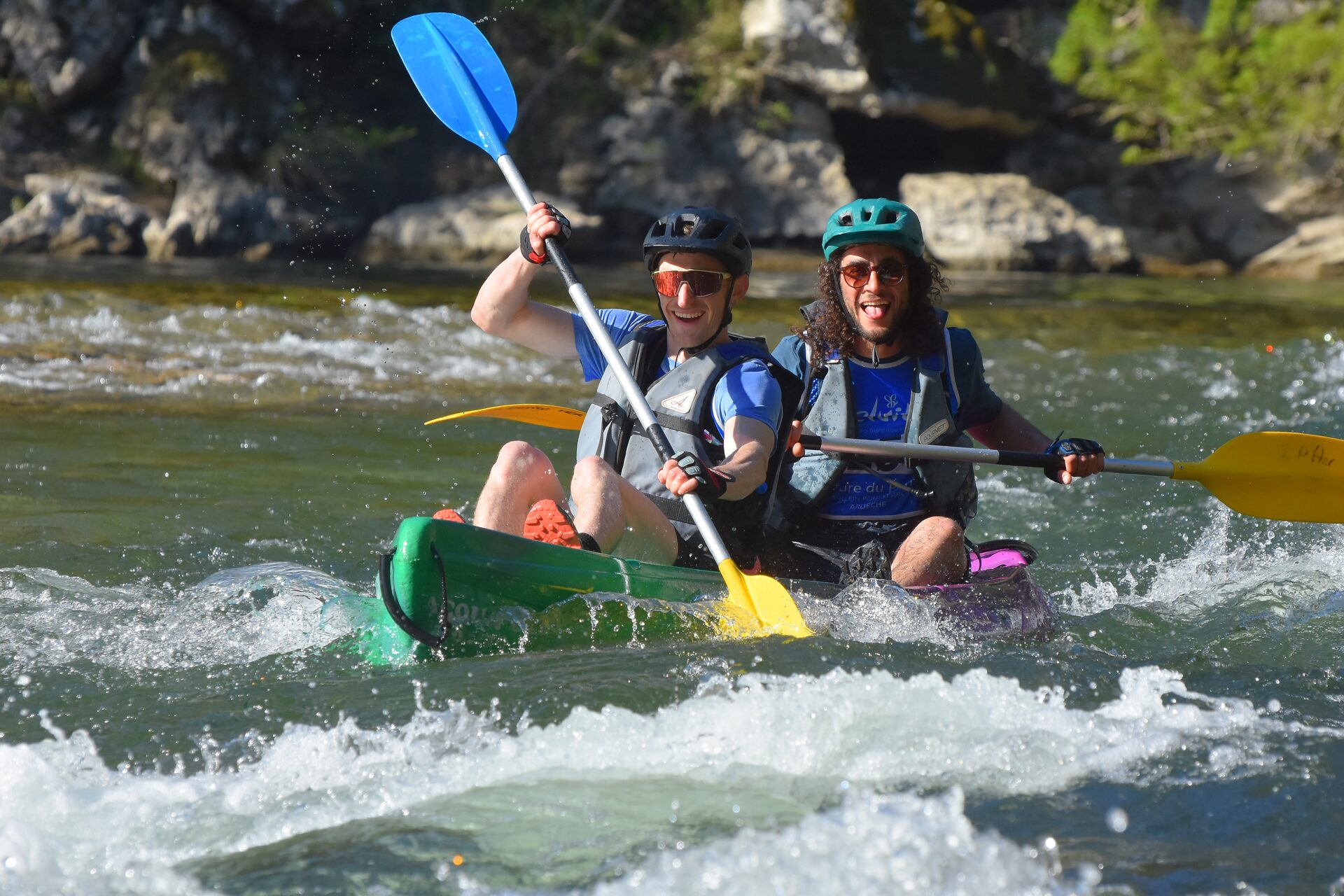 Duo d'équipiers détendus et souriants en canoë lors du raid en équipe de 2 en Ardèche à Vallon